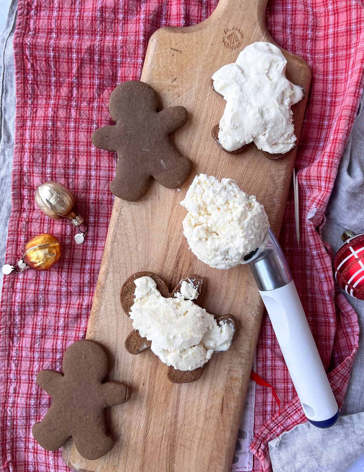 Gingerbread boy cookies with an ice cream scoop full of ice cream.