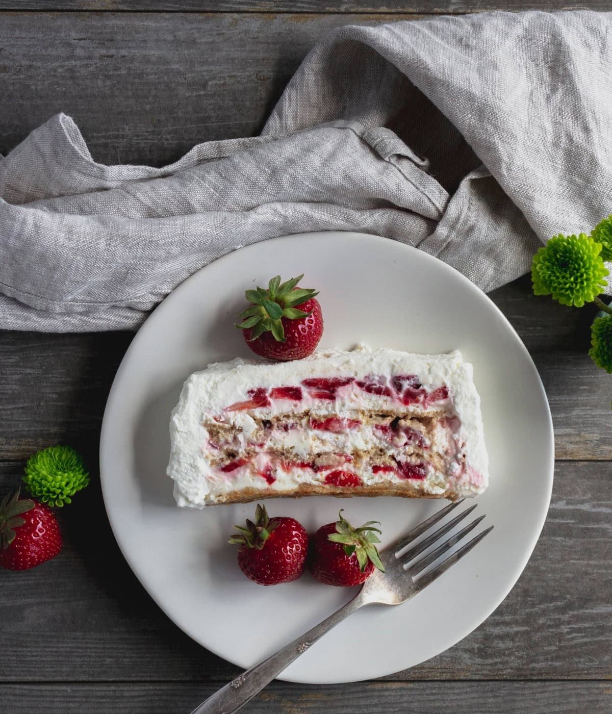 Slice of strawberries and cream cake on plate.