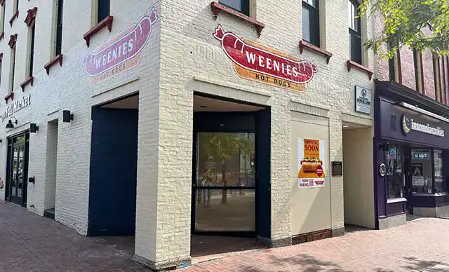 White brick building with hot dog logo