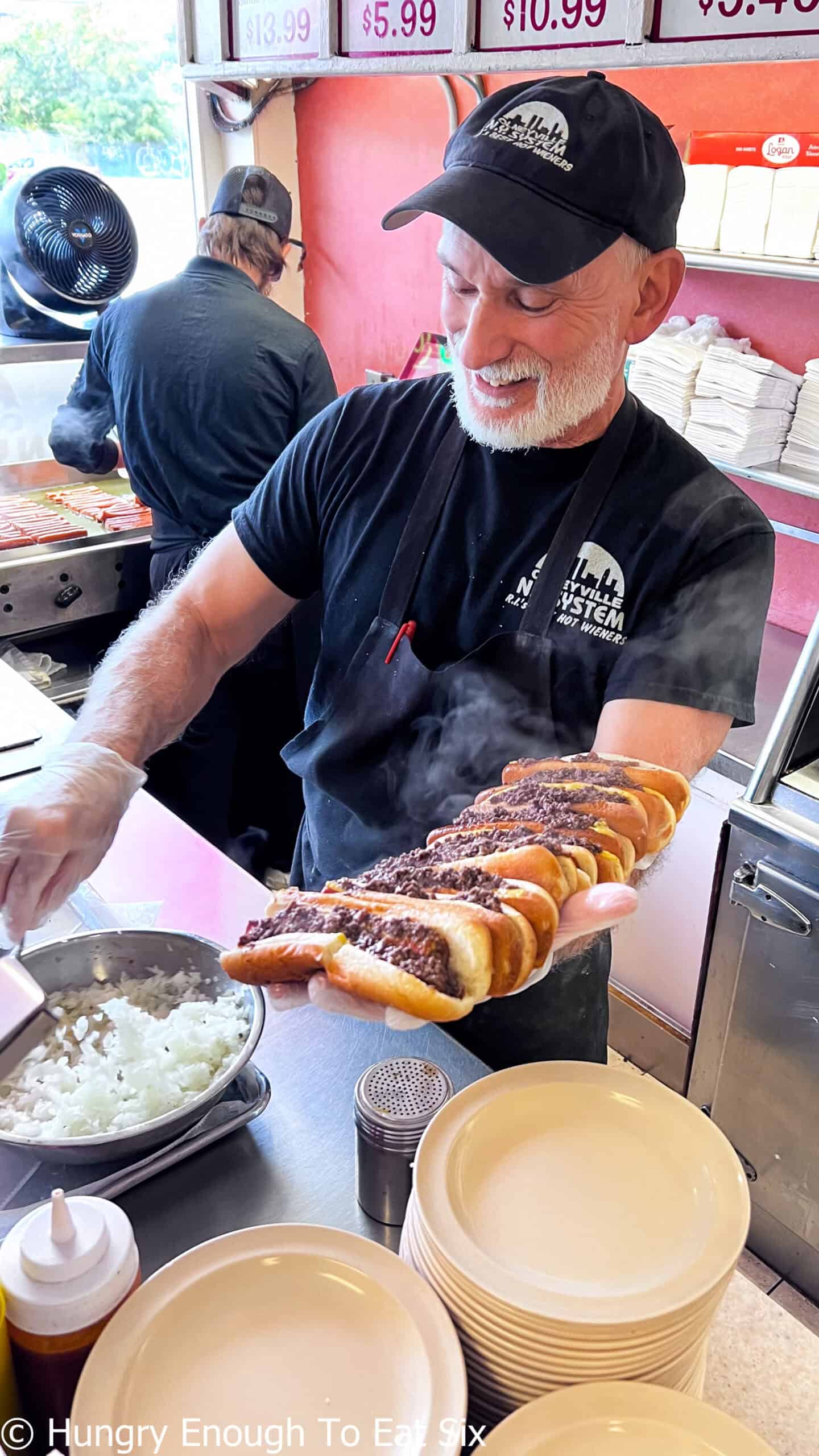 Employee with hot wieners in buns lined down his arm at Olneyville NY System in Providence, RI.