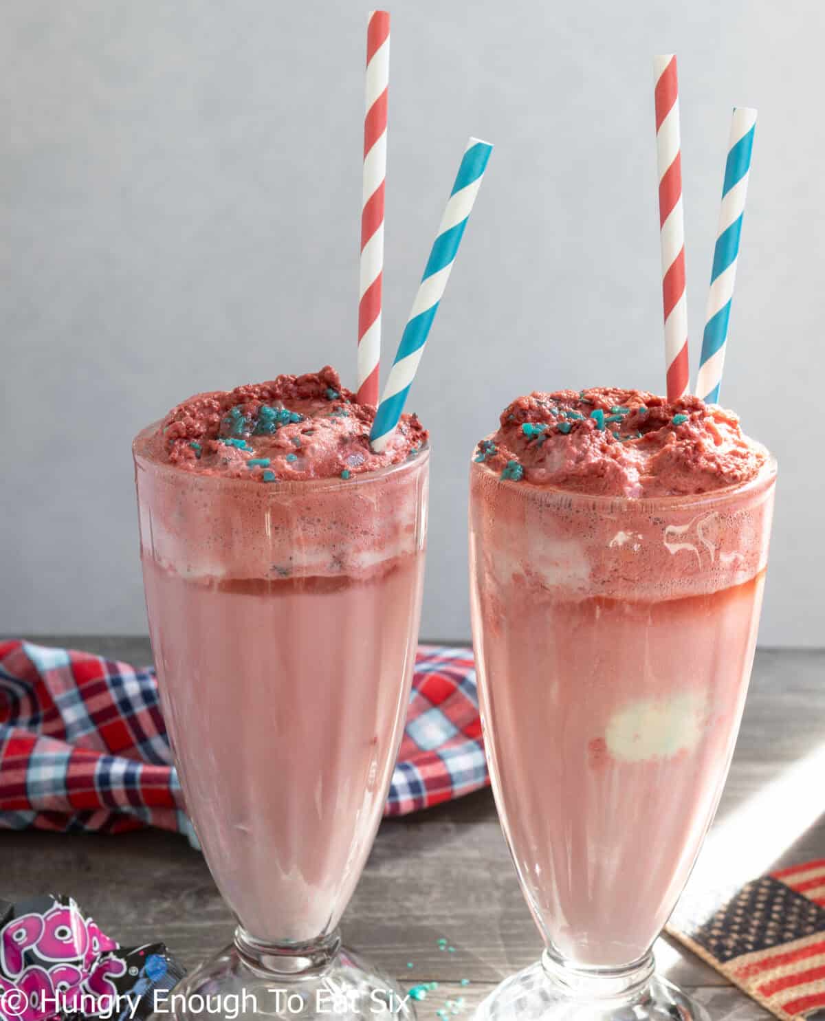 Two ice cream sodas with straws.
