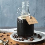 Glass bottle of coffee syrup on a wood board.