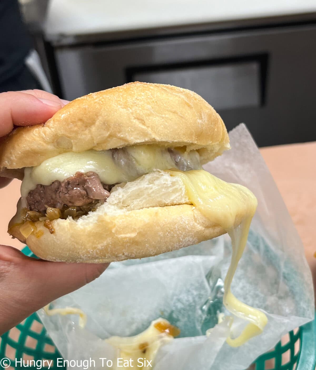 Burger on bun with lots of melted cheese.