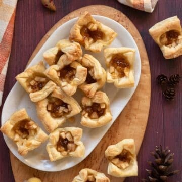 White platter holding pastry fig and apple brie bites.