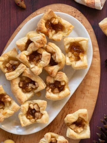 White platter holding pastry fig and apple brie bites.
