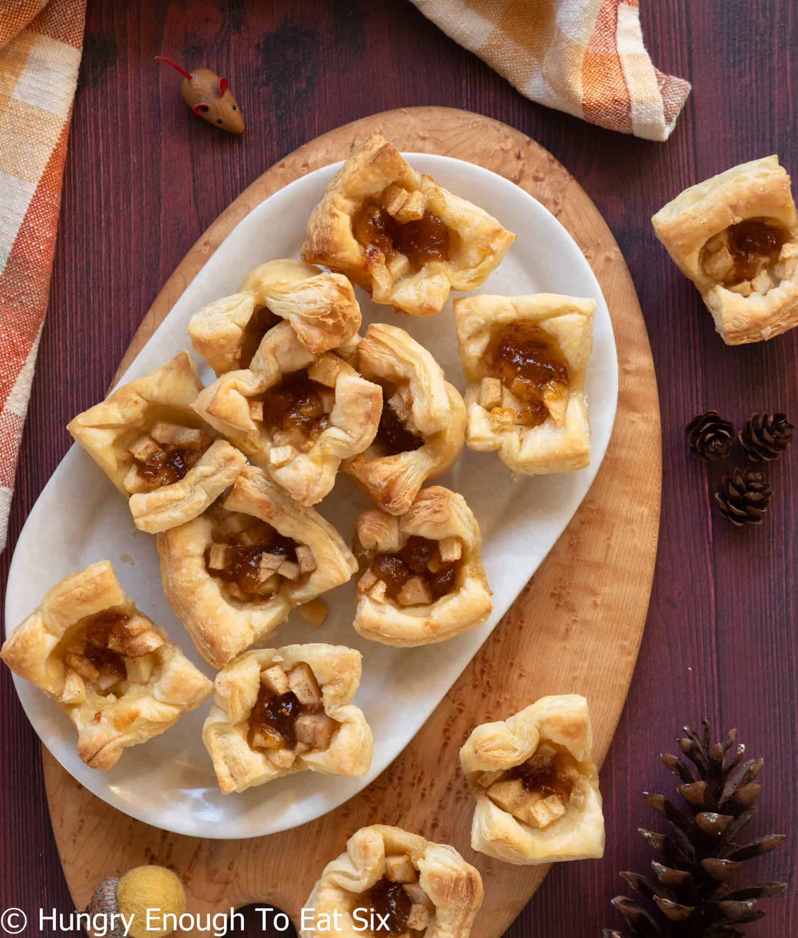 White oval platter holding a dozen baked apple fig brie bites.