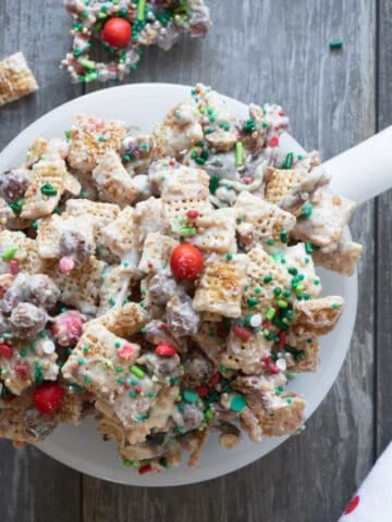 White bowl of white chocolate Chex mix with holiday sprinkles.