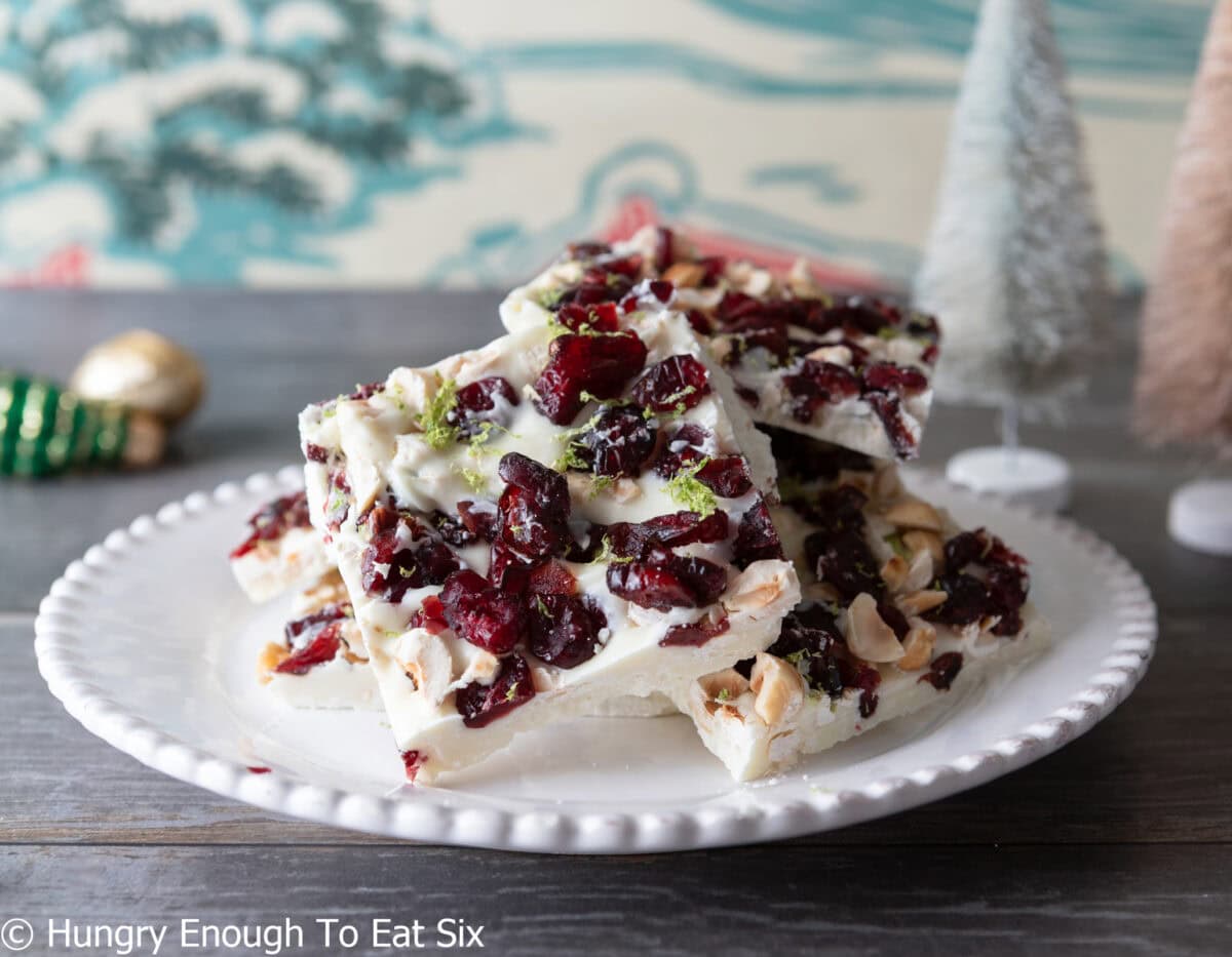 Squares of cranberry white chocolate bark dotted with cranberries and nuts.