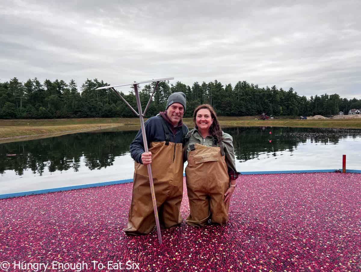 Couple with rake standing in water.