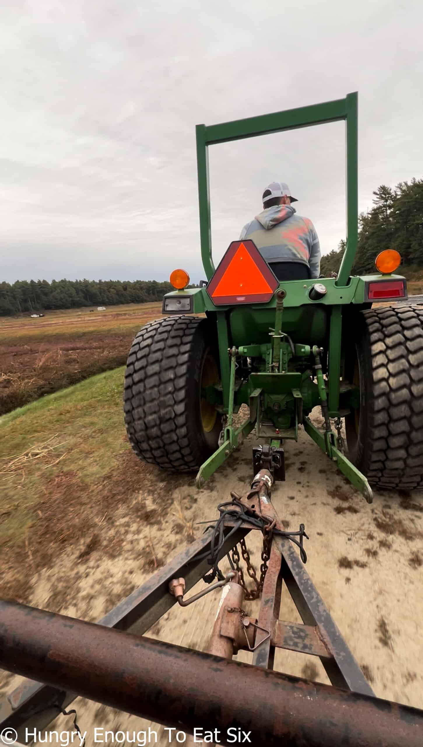 Large green tractor with orange reflector.