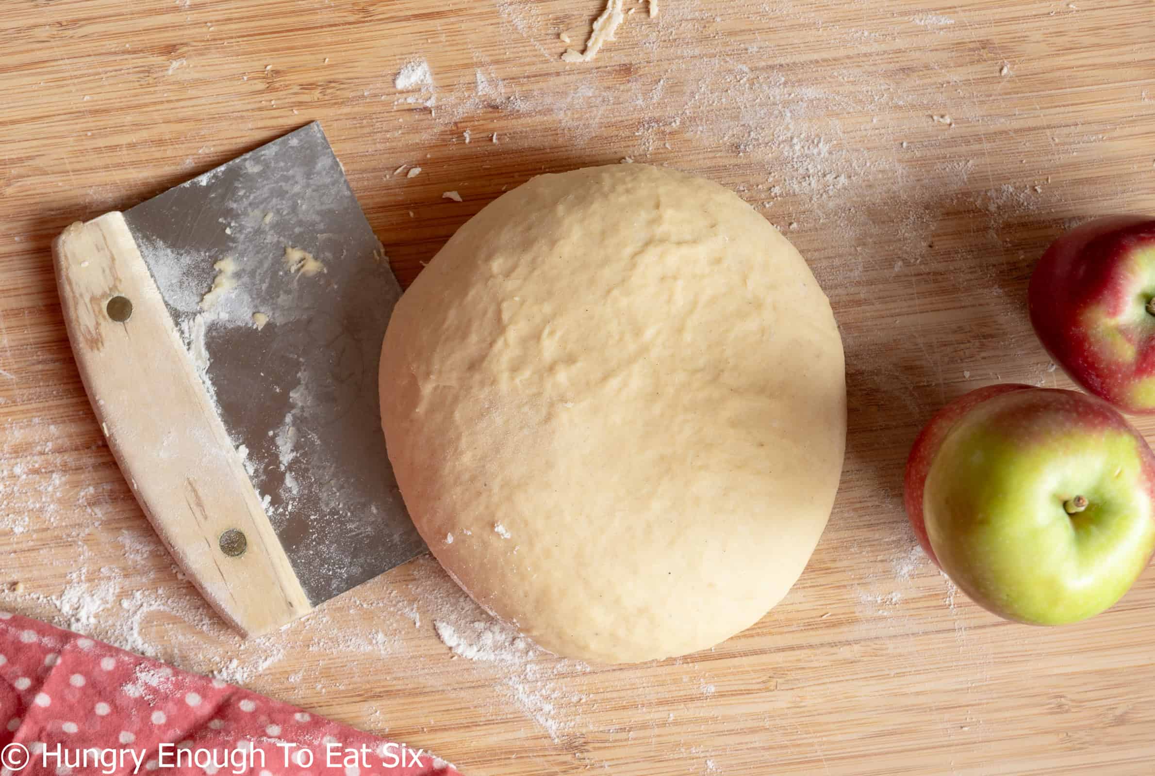 Round of dough on a cutting board.