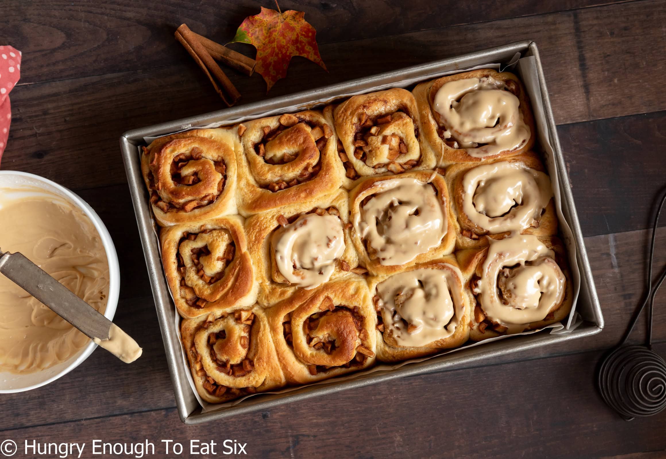 Baked cinnamon rolls, some with icing.