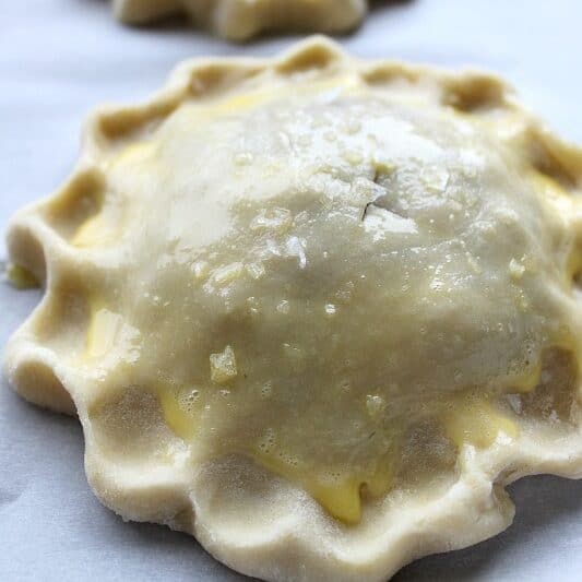 Unbaked hand pies with an all butter pastry crust brushed with egg yolk.