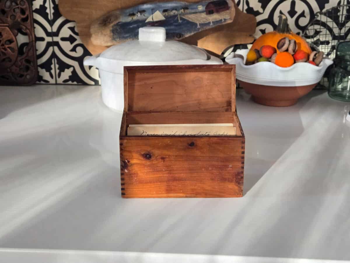 Wooden recipe box on a white marble counter. 