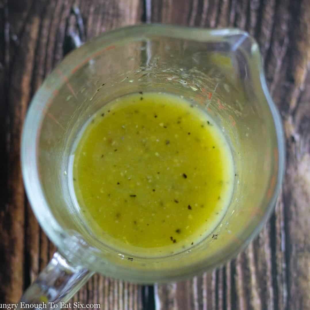 Mustard vinaigrette dressing in a measuring cup.