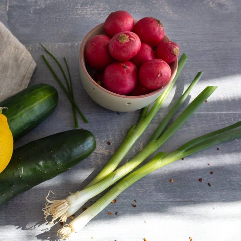 Fresh lemon, cucumbers, radishes, and green onions