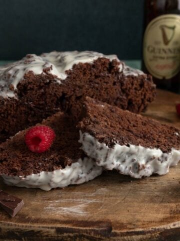 Loaf of chocolate Irish soda bread topped with white Irish whiskey glaze and sliced open.