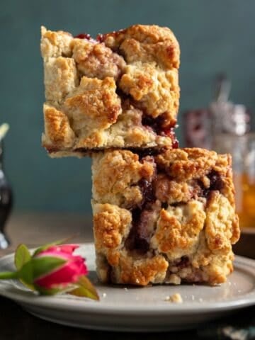 Two buttermilk scones with jam stacked on each other.