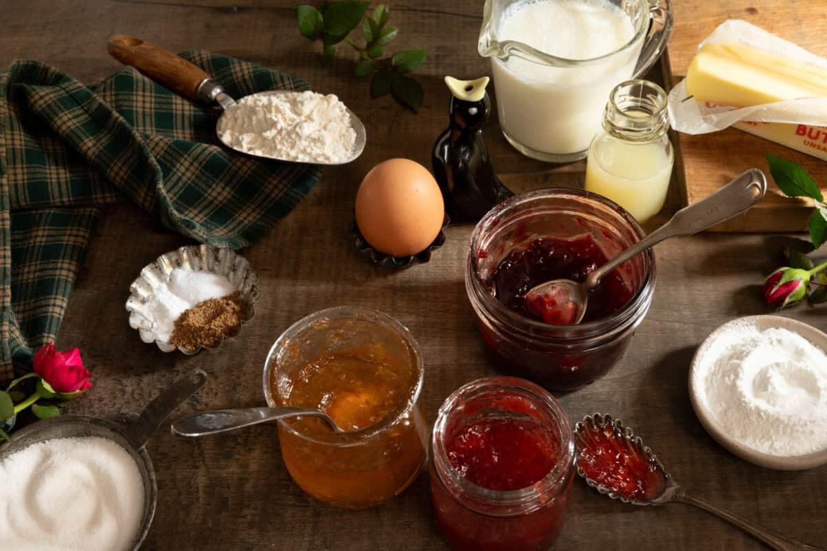 Ingredients that go into buttermilk scones: jam, egg, flour, sugar, baking powder and soda, coriander, buttermilk, butter.