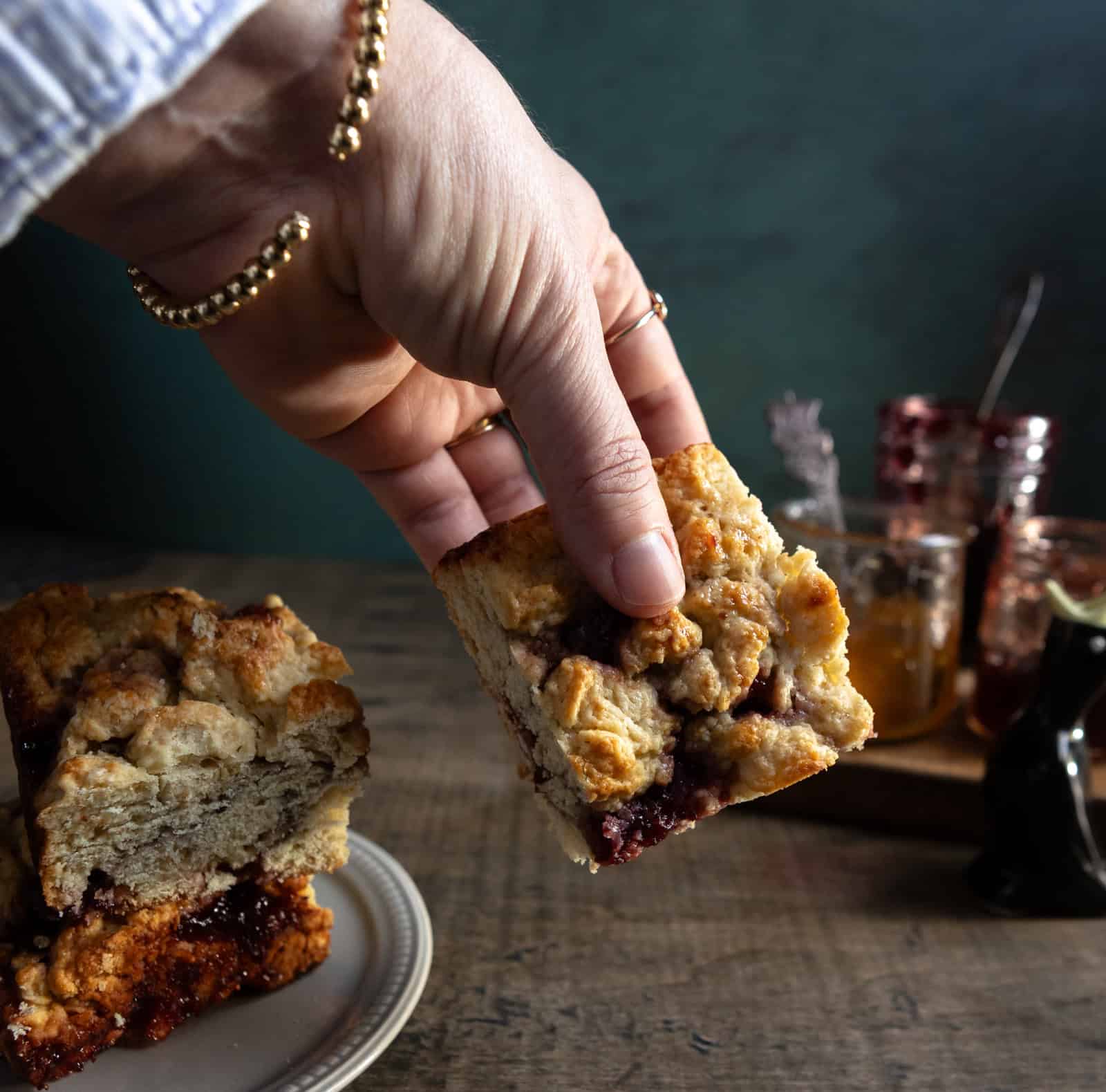 Hand holding a baked buttermilk scone square.