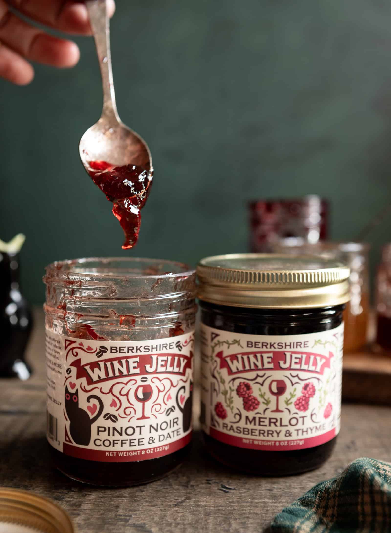 Spoonful of wine jelly over two wine jelly jars.