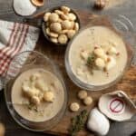 Two full bowls of New England no-clam chowder with crackers and shells.