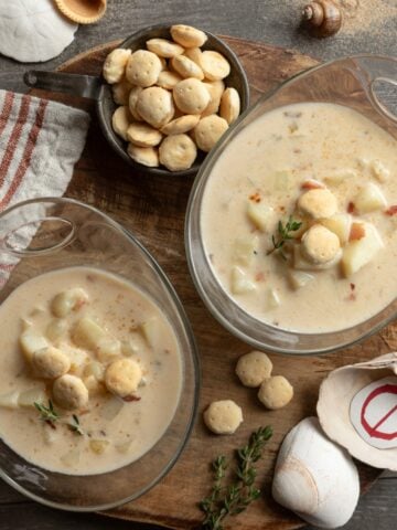 Two full bowls of New England no-clam chowder with crackers and shells.