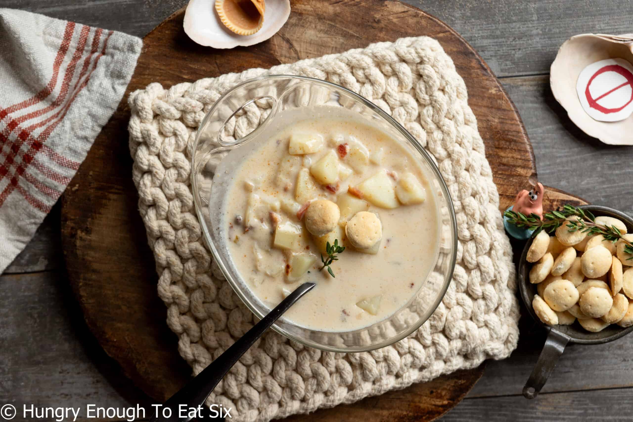 Glass bowl of New England no-clam chowder with crackers and a spoon