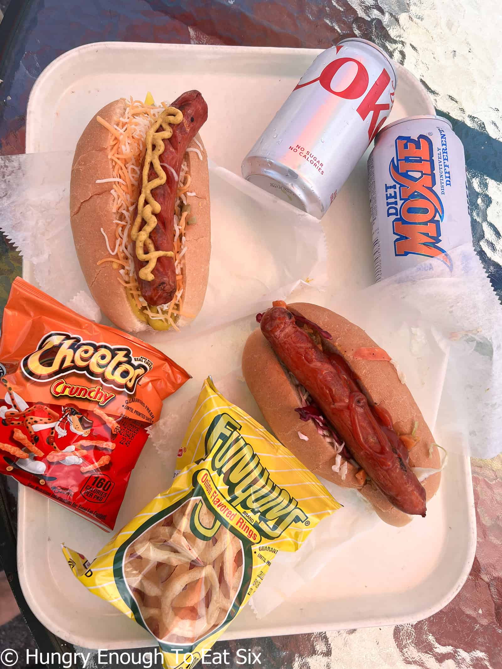 Dressed hot dogs with two cans of soda at Snappy Dogs, a central MA hot dog spot.