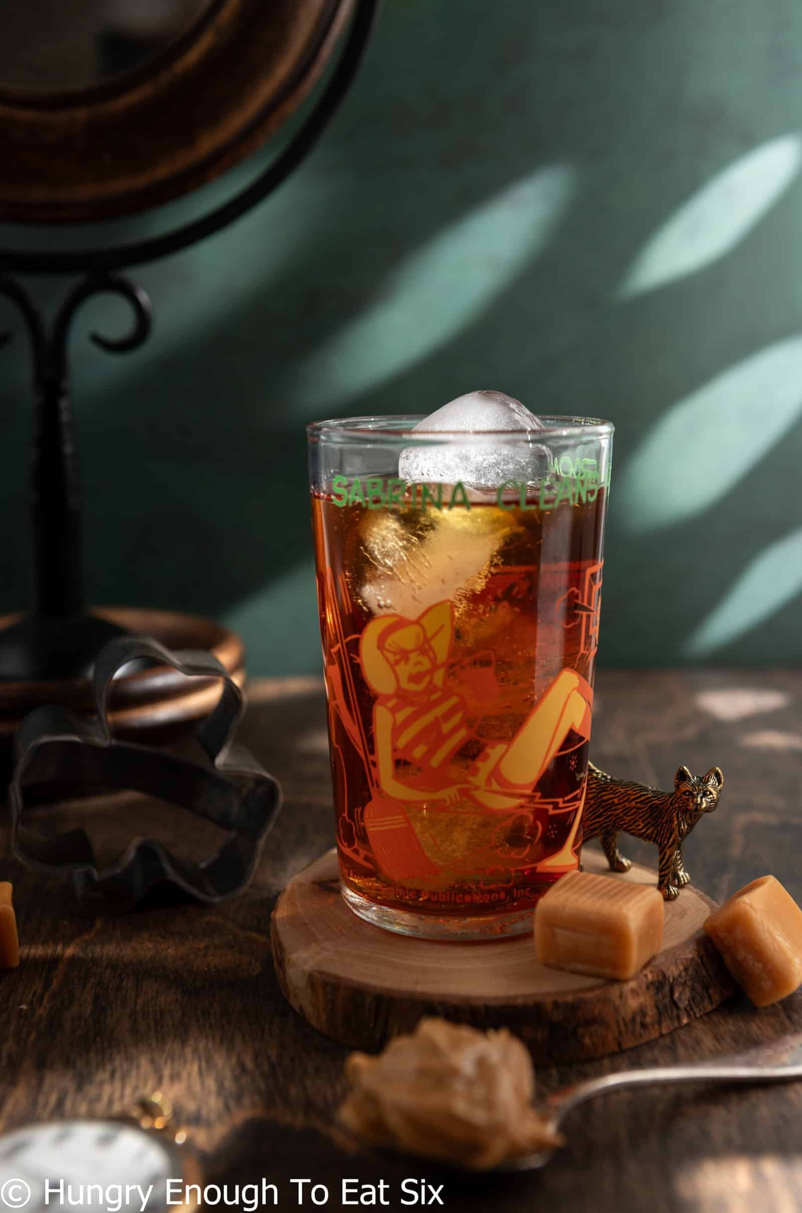 Character glass holding a brown, Friday Night cocktail drink.